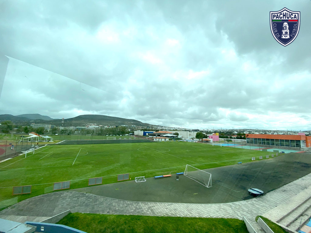 Cancha de pasto natural equipada con banquillos para dos equipos para uso de la Universidad del Futbol, fuerzas básicas y otros equipos del club.