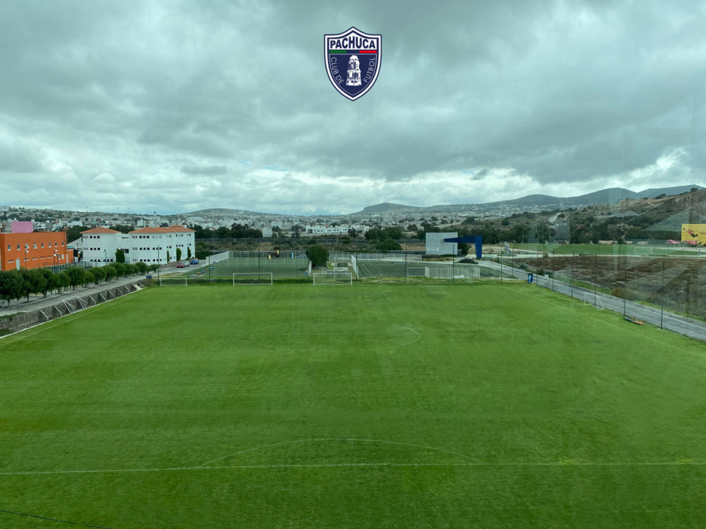 Cancha de pasto natural equipada con banquillos para dos equipos para uso de la Universidad del Futbol y fuerzas básicas.