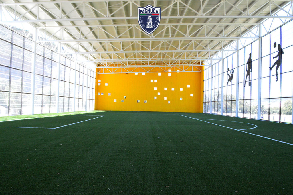 Cancha sintética dentro del Calero Center con iluminación y banquillos para dos equipos para uso de la Universidad del Futbol, primer equipo, fuerzas básicas y otros.